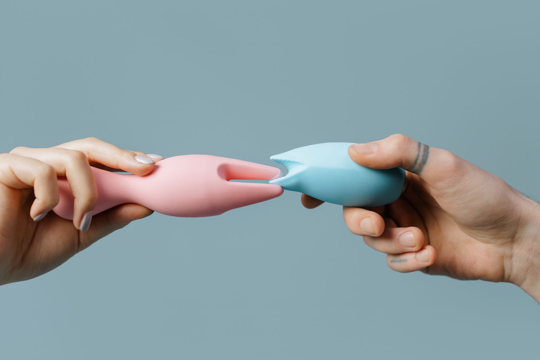 Couple standing together holding a blue vibrator, demonstrating modern intimacy and comfort with adult toys